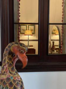 een houten kippenbeeld voor een spiegel bij Casa Colonial El Indiano in Las Palmas de Gran Canaria