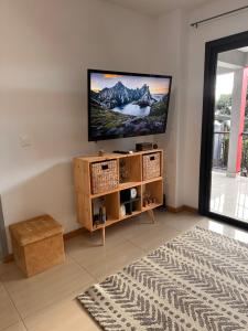 un soggiorno con TV a schermo piatto a parete di AFRICA a La Possession