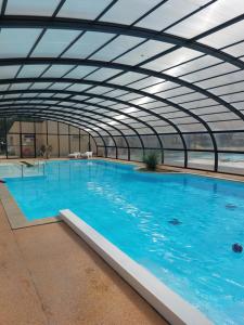 una gran piscina con techo de cristal en Mobil-home La perle bleue, en Ouistreham