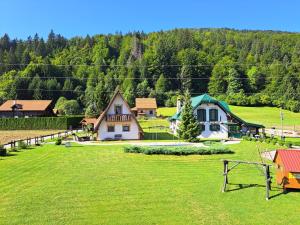 a group of houses in a field of grass at Prigorka, a fairytale house in Jasenak