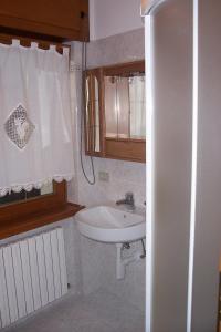 baño pequeño con lavabo y ventana en Fabbricato Indipendente Centro, en Lozzo Cadore