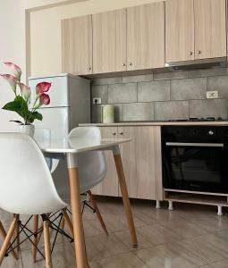 una cucina con tavolo, sedie e frigorifero di Sea View Apartment Anabel a Vlorë