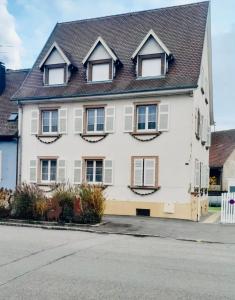 a white house with windows and a roof at L'Envolée Alsacienne - Magnifique appartement en duplex in Ostheim