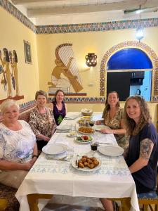 een groep vrouwen die rond een tafel zitten met eten bij Elphardous Hotel in Luxor