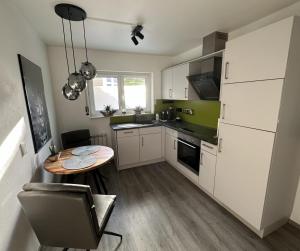 a kitchen with a table and a small table and a dining room at Nollywood-Apartment in Rheinfelden