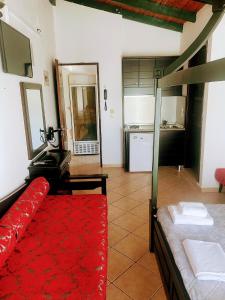 a living room with a red couch and a kitchen at Blue Bay Beach Hotel in Koinyra