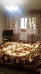 - une chambre avec un grand lit fleuri dans l'établissement Роза, à Bishkek