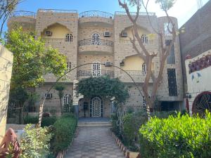 un edificio con una escalera que conduce a la puerta principal en Elphardous Hotel, en Luxor