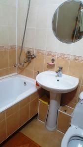 La salle de bains est pourvue d'un lavabo, de toilettes et d'un miroir. dans l'établissement Роза, à Bishkek