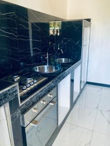 eine schwarze Theke mit zwei Waschbecken in einer Küche in der Unterkunft Apartaments B&M in Ischia