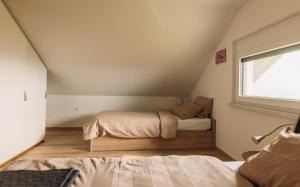 um pequeno quarto com uma cama e uma janela em Apartma Hiša na Ravnah em Pišece