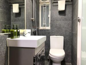 a bathroom with a toilet and a sink and a mirror at 香港名都商务旅馆 self-check-in in Hong Kong