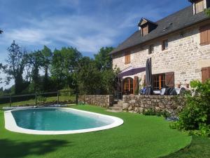 una imagen de una piscina frente a una casa en La grange de Salvaneix Gîte pour 15 personnes 7 chambres avec 6 sdb-6wc, en Sarran