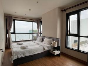 a bedroom with a bed with a large window at The Base Central Pattaya by Adam in Pattaya Central