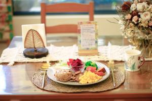 a table with a plate of food on a table at Pottery Flower B&B in Jiji