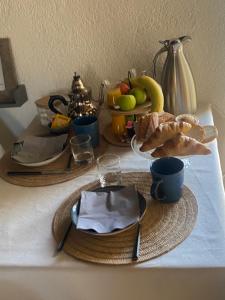 a table with a plate of food and fruit on it at La Maison du Commandeur in Maine-de-Boixe