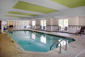 une grande piscine avec des chaises et des tables dans l'établissement Fairfield Inn & Suites Milledgeville, à Milledgeville