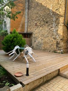 una silla y una mesa en una terraza de madera en Un trou de verdure, en Charleville-Mézières