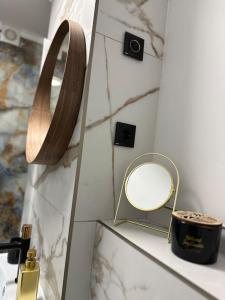 a mirror on a counter next to a vanity with a mirror at Priveé Residence in Caransebeş