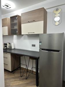 a kitchen with a stainless steel refrigerator and a counter at Priveé Residence in Caransebeş