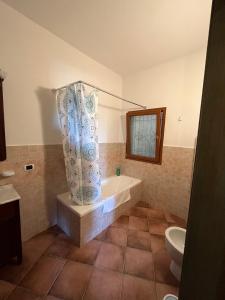 e bagno con vasca, servizi igienici e tenda per la doccia. di Venti di Vacanza - Levante & Grecale a Olbia