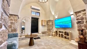 uma sala de estar com uma grande televisão de ecrã plano na parede em Knight house Akko em Acre