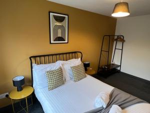Schlafzimmer mit einem Bett mit weißer Bettwäsche und Kissen in der Unterkunft 3 bedroom house with parking in Manchester