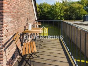 eine Terrasse mit zwei Bänken und einem Tisch auf einem Gebäude in der Unterkunft Studio-Apartment "Charlotte" in Westerstede