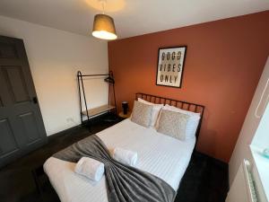 マンチェスターにある3 bedroom house with parkingの白いシーツと枕が備わったベッドのある寝室