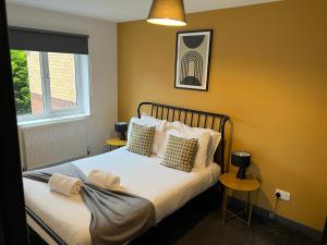ein Schlafzimmer mit einem Bett mit zwei Tischen und einem Fenster in der Unterkunft 3 bedroom house with parking in Manchester