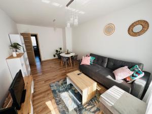 uma sala de estar com um sofá e uma mesa em Apartament Neustettin-Polna Szczecinek em Szczecinek