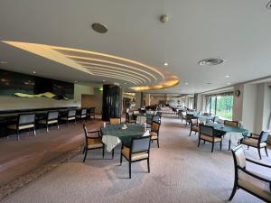 Villa The Club 御殿場ウエスト في غوتيمبا: مطعم فيه طاولات وكراسي في الغرفة