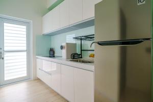 頭城的住宿－宜蘭狗窩民宿，厨房配有白色橱柜和不锈钢冰箱