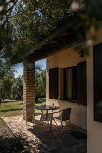 une terrasse avec une table et des chaises devant une maison dans l'établissement Tenuta Querce Grosse- Le Dimore, à Francavilla al Mare