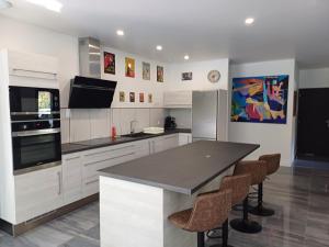 a kitchen with white cabinets and a black counter top at Magnifique villa avec piscine in Biscarrosse