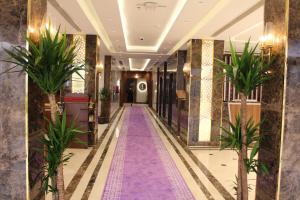 un pasillo con palmeras en el vestíbulo del hotel en فندق فاندال, en Jazan