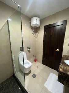 a bathroom with a toilet and a glass shower stall at Crystal Blue Rabigh 2 in Rabigh