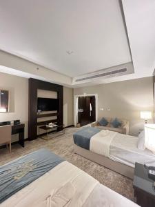 a hotel room with two beds and a flat screen tv at Crystal Blue Rabigh 2 in Rabigh