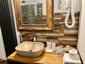 a bathroom with a white sink and a mirror at Fronius Boutique Residence in Sighişoara +100 photos