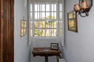 una mesa pequeña en un pasillo con ventana en Casa de Aldeia, en Penafiel