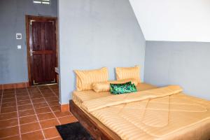 a large bed in a room with a blue wall at Sabay Farm in Kampot