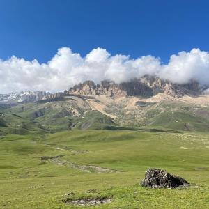 een groen veld met een berg op de achtergrond bij Mountain house in Xınalıq