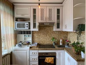 a kitchen with white cabinets and a sink at Two-Bedroom Apartment in Ulaanbaatar