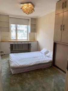 1 dormitorio con cama y lámpara de araña en Two-Bedroom Apartment en Ulán Bator
