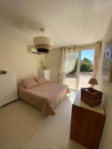 ein Schlafzimmer mit einem Bett und einem großen Fenster in der Unterkunft Villa Le week end in Ajaccio