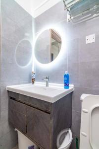 ein Badezimmer mit einem Waschbecken, einem Spiegel und einem WC in der Unterkunft Luxury 1 BDRM apartment Kilimani in Nairobi