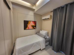 um pequeno quarto com uma cama e um quadro na parede em CasaBeNi staycation em Manila