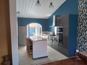 una cucina con pareti blu e piano di lavoro bianco di Le djebel a Cilaos