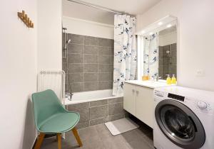 een badkamer met een wasmachine en een groene stoel bij Le 24 Nautic, Appartement douillet Bassin olympique Disneyland & Paris avec parking in Vaires-sur-Marne