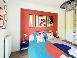een slaapkamer met een rode accentmuur en een bed bij Le 24 Nautic, Appartement douillet Bassin olympique Disneyland & Paris avec parking in Vaires-sur-Marne